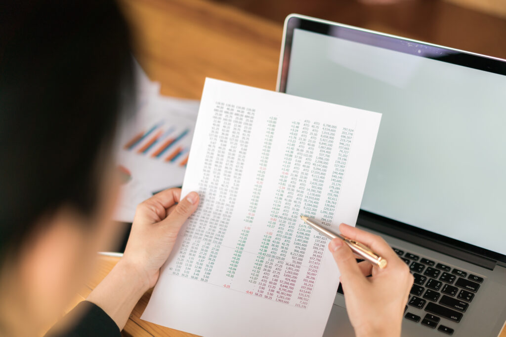 Business woman hand with Financial charts and laptop on the tabl